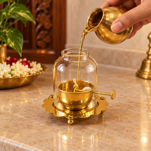 Brass akhand diya lit inside its glass dome